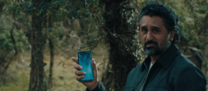 A person in a forest holding a smartphone.