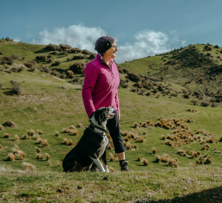 A woman with a dog in remote farmland.